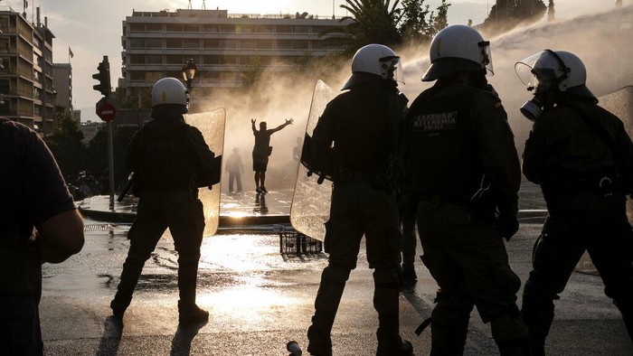 Greek police use tear gas and water cannons to disperse anti-vaccine protesters during a rally at Syntagma square, central Athens, on Wednesday, July 21, 2021. Thousands of people protested against Greek government's measures to curb rising COVID-19 infections and drive up vaccinations in the country where almost 50% of Greeks and country residents have received at least one dose of the vaccine. (AP Photo/Yorgos Karahalis)