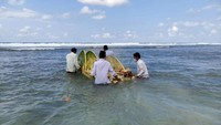Bersamaan usainya pembacaan doa, beberapa pria bergegas menuju tempat sesaji berada. Mereka lantas mengangkat rakitan batang pisang dengan ornamen janur. Diiringi teriakan takbir, mereka lalu membawanya ke laut.
