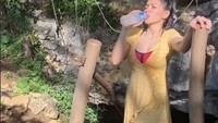 Liburan santai, Angel pasang pose sensual sambil menikmati air mineral dingin setelah dia menelusuri alam yang ada di Rangko. Foto: Instagram Angel Karamoy