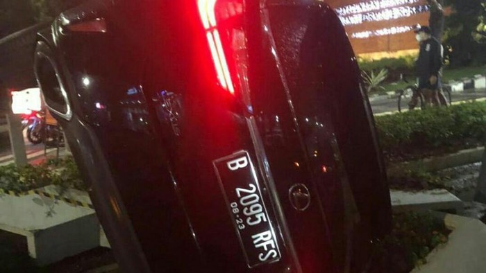Mobil Lexus berpelat RFS terguling di Bundaran Senayan, Sabtu (24/7/2021).