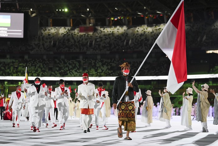 TOKYO, JAPAN - JULY 23: Flag bearer Nurul Akmal of Team Indonesia leads his team out during the Opening Ceremony of the Tokyo 2020 Olympic Games at Olympic Stadium on July 23, 2021 in Tokyo, Japan. (Photo by Matthias Hangst/Getty Images)