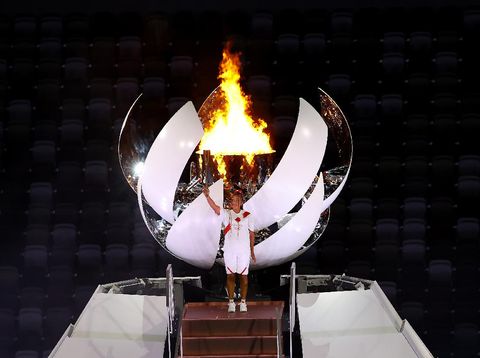 TOKYO, JAPAN - JULY 23: Naomi Osaka of Team Japan holds up the Olympic torch after lighting the Olympic cauldron during the Opening Ceremony of the Tokyo 2020 Olympic Games at Olympic Stadium on July 23, 2021 in Tokyo, Japan. (Photo by Laurence Griffiths/Getty Images)
