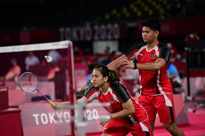 Indonesias Melati Daeva Oktavianti (C) hits a shot next to partner Praveen Jordan in their mixed doubles badminton group stage match against Australias Simon Wing Hang Leung and Gronya Somerville during the Tokyo 2020 Olympic Games at the Musashino Forest Sports Plaza in Tokyo on July 24, 2021. (Photo by Pedro PARDO / AFP)
