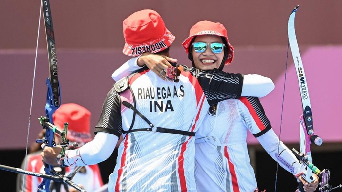 Indonesias Diananda Choirunisa (R) and Riau Salsabila celebrate after beating the USA in the mixed team eliminations during the Tokyo 2020 Olympic Games at Yumenoshima Park Archery Field in Tokyo on July 24, 2021. (Photo by ADEK BERRY / AFP)