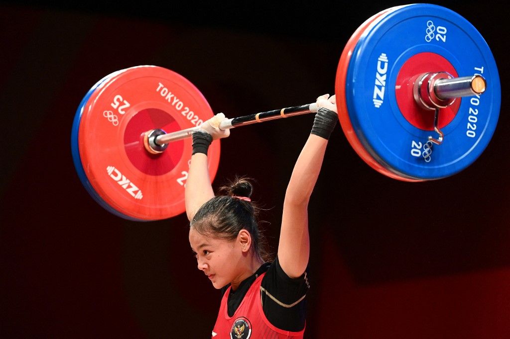 Indonesia's Windy Cantika Aisah competes in the women's 49kg weightlifting competition during the Tokyo 2020 Olympic Games at the Tokyo International Forum in Tokyo on July 24, 2021. (Photo by Vincenzo PINTO / AFP)