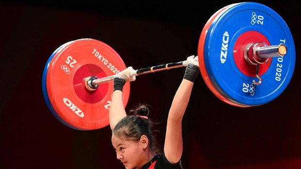 Indonesia's Windy Cantika Aisah competes in the women's 49kg weightlifting competition during the Tokyo 2020 Olympic Games at the Tokyo International Forum in Tokyo on July 24, 2021. (Photo by Vincenzo PINTO / AFP)