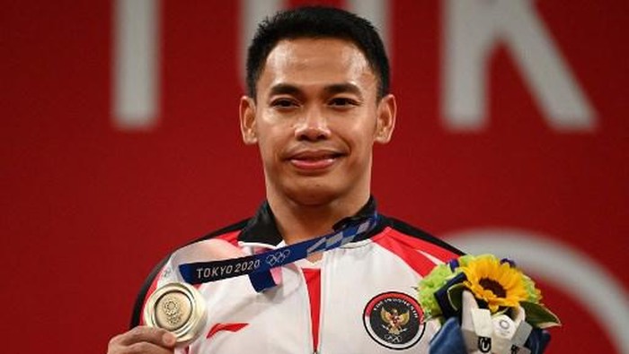 Silver medallist Indonesias Eko Yuli Irawan stands on the podium for the victory ceremony of the mens 61kg weightlifting competition during the Tokyo 2020 Olympic Games at the Tokyo International Forum in Tokyo on July 25, 2021. (Photo by Vincenzo PINTO / AFP)