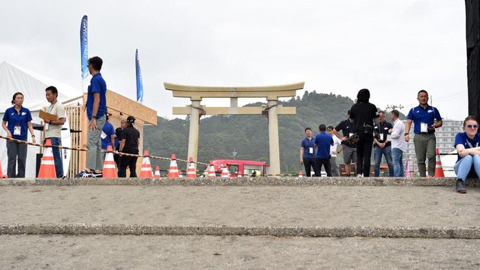 Gerbang masuk venue surfing Olimpiade 2020 Toky o di Pantai Tsuragasaki Competition officials gather at an entrance of the men's rounds surfing test event for Tokyo 2020 Olympic Games at Tsurigasaki Surfing Beach in Ichinomiya, Chiba Prefecture on July 18, 2019. (Photo by Kazuhiro NOGI / AFP)