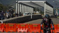 Sejumlah pengendara melintas pada sisi jalur Jembatan Sungai Citarum yang ditutup di Jalan Raya Dayeuhkolot, Kabupaten Bandung, Jawa Barat, Minggu (25/7/2021).