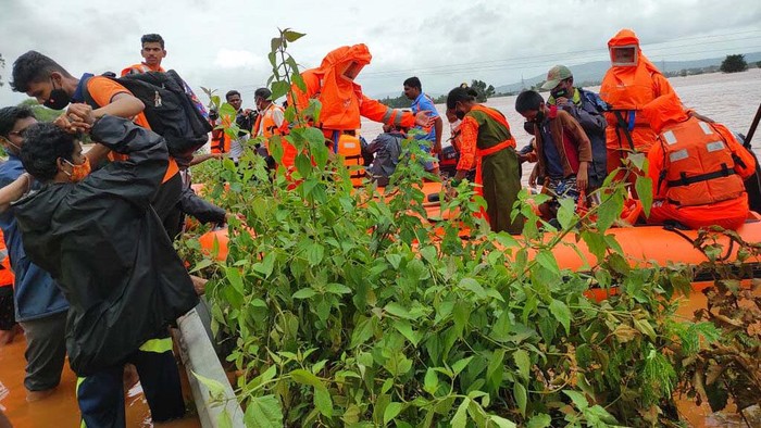 Korban Tewas Akibat Longsor di India Terus Bertambah People stranded in flood waters watch others being rescued at Kolhapur in western Maharashtra state, India, Saturday, July 24, 2021. Officials say landslides and flooding triggered by heavy monsoon rain have killed more than 100 people in western India. More than 1,000 people trapped by floodwaters have been rescued. (AP Photo)