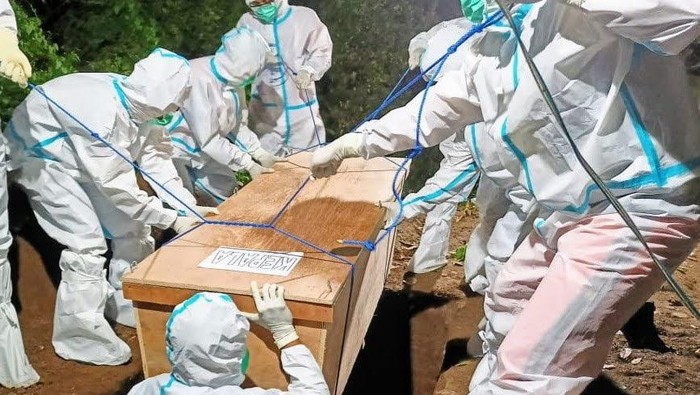 relawan tim pemulasaraan jenazah saat memakamkan pasien COVID-19