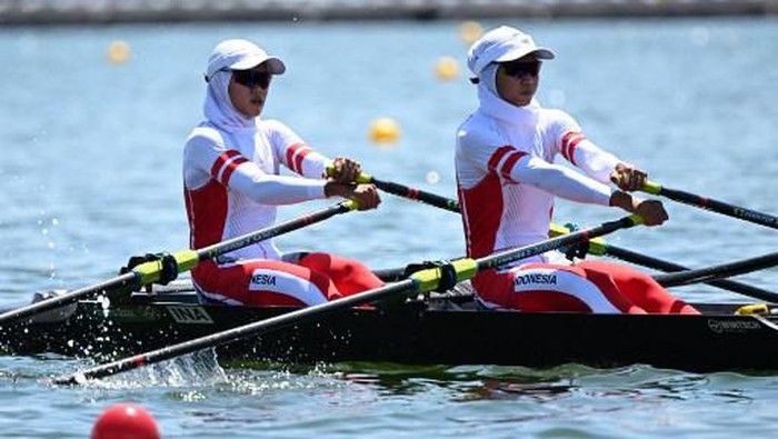 (L-R) Indonesias Mutiara Putri and Indonesias Melani Putri compete in the lightweight womens double sculls repechage during the Tokyo 2020 Olympic Games at the Sea Forest Waterway in Tokyo on July 25, 2021. (Photo by Charly TRIBALLEAU / AFP)