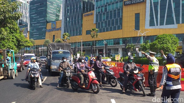 Sejumlah jalan di Surabaya tampak masih disekat di hari pertama perpanjangan PPKM level 4. Hanya kendaraan sektor esensial dan kritikal yang diizinkan lewat.