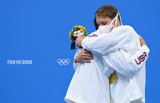 Silver medallist USA's Jay Litherland (L) and gold medallist USA's Chase Kalisz hug each other on the podium after the final of the men's 400m individual medley swimming event during the Tokyo 2020 Olympic Games at the Tokyo Aquatics Centre in Tokyo on July 25, 2021. (Photo by Jonathan NACKSTRAND / AFP) / The erroneous mention[s] appearing in the metadata of this photo by Jonathan NACKSTRAND has been modified in AFP systems in the following manner: [Silver medallist USA's Jay Litherland] instead of [Bronze medallist USA's Jay Litherland]. Please immediately remove the erroneous mention[s] from all your online services and delete it (them) from your servers. If you have been authorized by AFP to distribute it (them) to third parties, please ensure that the same actions are carried out by them. Failure to promptly comply with these instructions will entail liability on your part for any continued or post notification usage. Therefore we thank you very much for all your attention and prompt action. We are sorry for the inconvenience this notification may cause and remain at your disposal for any further information you may require.