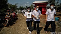 Keluarga membawa abu jenazah korban COVID-19.