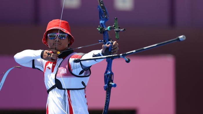 TOKYO, JAPAN - JULY 24: Riau Ega Salsabilla of Team Indonesia competes in the Mixed Team 1/8 Eliminations on day one of the Tokyo 2020 Olympic Games at Yumenoshima Park Archery Field on July 24, 2021 in Tokyo, Japan. (Photo by Justin Setterfield/Getty Images)