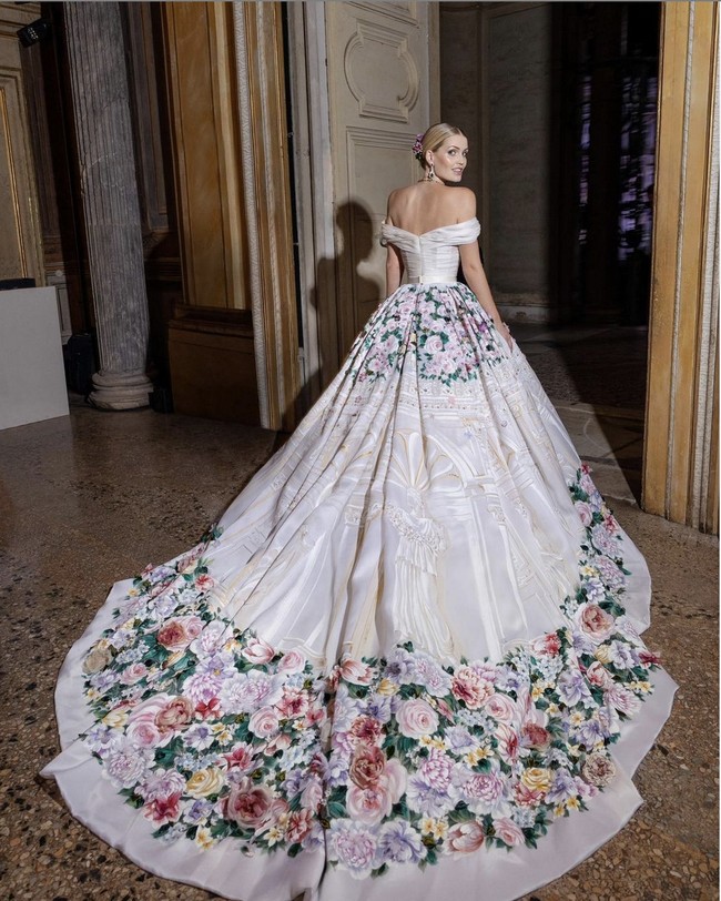 Setelah upacara pernikahan, sang pengantin mengganti gaun putihnya dengan gaun yang tak kalah mewah. Gaun strapless berbahan organza dengan hiasan lukisan tangan serta aplikasi bunga dan kristal ini dikenakannya saat makan malam. Foto: Dok. Dolce & Gabbana