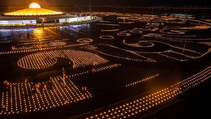 Umat Buddha di Thailand merayakan Hari Asalha Puja di tengah pandemi Corona. Ribuan lilin disiapkan untuk menerangi kuil saat perayaan Asalha Puja.