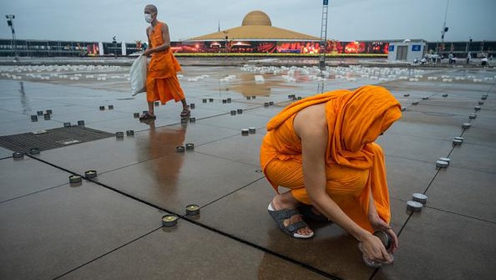 Umat Buddha di Thailand merayakan Hari Asalha Puja di tengah pandemi Corona. Ribuan lilin disiapkan untuk menerangi kuil saat perayaan Asalha Puja.