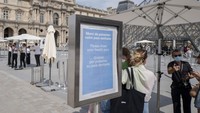 Papan informasi bertuliskan pemberitahuan bagi para pengunjung untuk menunjukkan kartu sehat saat akan memasuki museum terlihat di depan Museum Louvre yang berada di kawasan Paris, Prancis. AP Photo/Rafael Yaghobzadeh.