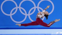 Atlet Jerman Pauline Schaefer-Betz saat melakukan gerakan dalam kualifikasi nomor senam artistik di Olimpiade Tokyo (25/7).  Biasanya, pesenam wanita menggunakan kostum leotard yang mirip bikini. Kostum itu mengikuti bentuk tubuh, menutupi lengan, dan hanya sampai bagian panggul. (AP Photo/Gregory Bull)