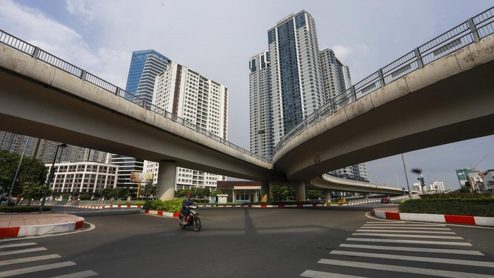Virus Outbreak Vietnam A man rides a scooter across a quiet intersection in Ho Chi Minh City, Vietnam, Monday, July 26, 2021. Vietnam's southern metropolis Ho Chi Minh City has tightened restrictions with a curfew order starting from Monday evening to contain a surge of COVID-19. (AP Photo/Huu Khoa)