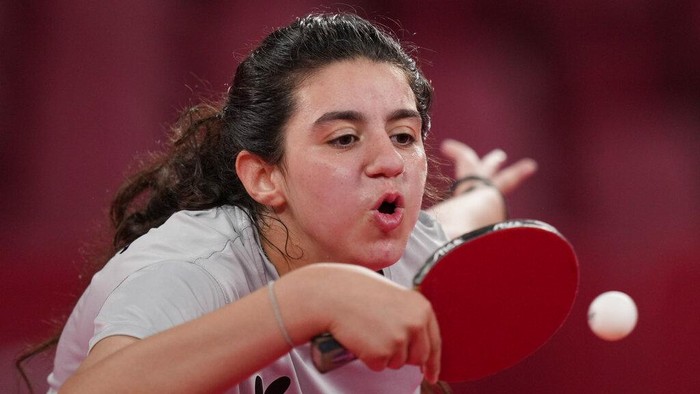Aksi Hend Zaza, Atlet Termuda Olimpiade Tokyo 2020 Syria's Hend Zaza catches a ball during women's table tennis singles preliminary round match against Austria's Liu Jia at the 2020 Summer Olympics, Saturday, July 24, 2021, in Tokyo. (AP Photo/Kin Cheung)