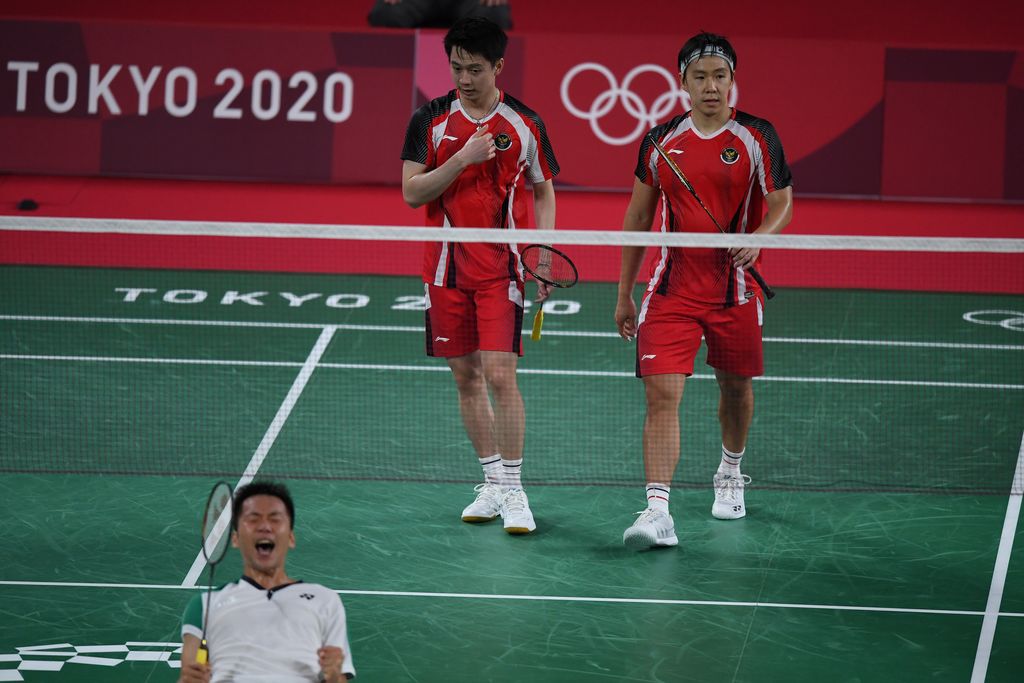 Ganda putra Indonesia Marcus Fernaldi Gideon (kanan) dan Kevin Sanjaya Sukamuljo (kedua kanan) berjalan seusai kalah dari ganda putra Taiwan Yang Lee/Chi-Lin Wang dalam penyisihan Grup A Olimpiade Tokyo 2020 di Musashino Forest Sport Plaza, Tokyo, Jepang, Selasa (27/7/2021). Marcus dan Kevin kalah 18-21, 21-15, 17-21. ANTARA FOTO/Sigid Kurniawan/hp.