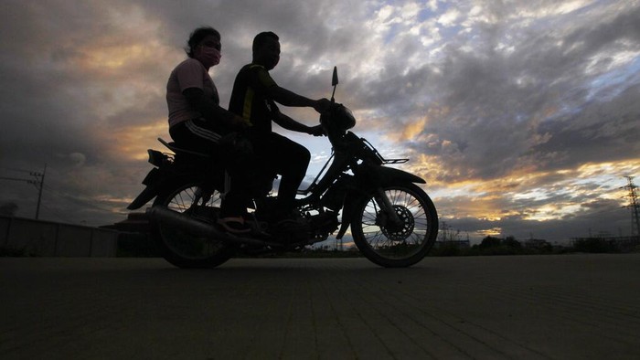 A boy  helps his father collect lotus flowers to sell in the market in Krasaing Chrum village on the outskirts of Phnom Penh, Cambodia, Thursday, July 22, 2021. (AP Photo/Heng Sinith)