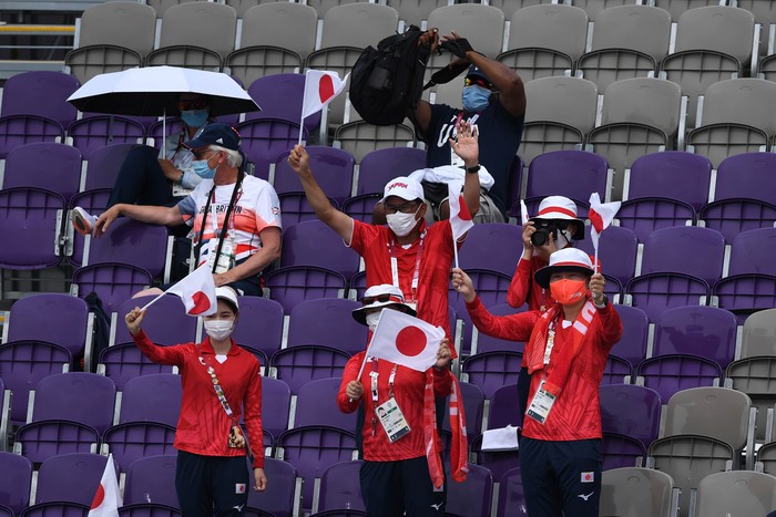 Sejumlah relawan beristirahat sambil memberikan dukungan saat pertandingan panahan Olimpiade Tokyo 2020 di Yumenoshima Park Archery Field, Tokyo, Jepang, Senin (26/7/2021). Penyelenggaraan Olimpiade yang diselenggarakan tanpa penonton dari kalangan umum tersebut merupakan keputusan di tengah kondisi darurat COVID-19 yang sedang diberlakukan di Ibu Kota Jepang. ANTARA FOTO/Sigid Kurniawan/wsj.