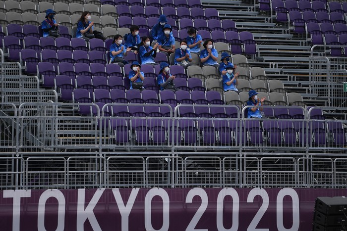 Sejumlah relawan beristirahat sambil memberikan dukungan saat pertandingan panahan Olimpiade Tokyo 2020 di Yumenoshima Park Archery Field, Tokyo, Jepang, Senin (26/7/2021). Penyelenggaraan Olimpiade yang diselenggarakan tanpa penonton dari kalangan umum tersebut merupakan keputusan di tengah kondisi darurat COVID-19 yang sedang diberlakukan di Ibu Kota Jepang. ANTARA FOTO/Sigid Kurniawan/wsj.