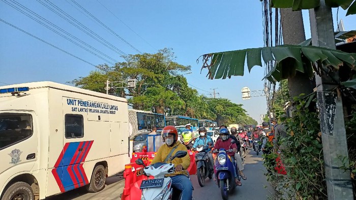 Antrean kendaraan mengular di titik penyekatan Pesing, Jakarta Barat, Selasa (27/7/2021).