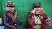  Warga menunjukan BLT yang diterimanya. Program door to door ini untuk mengurangi kerumunan penyaluran di kantor kelurahan.