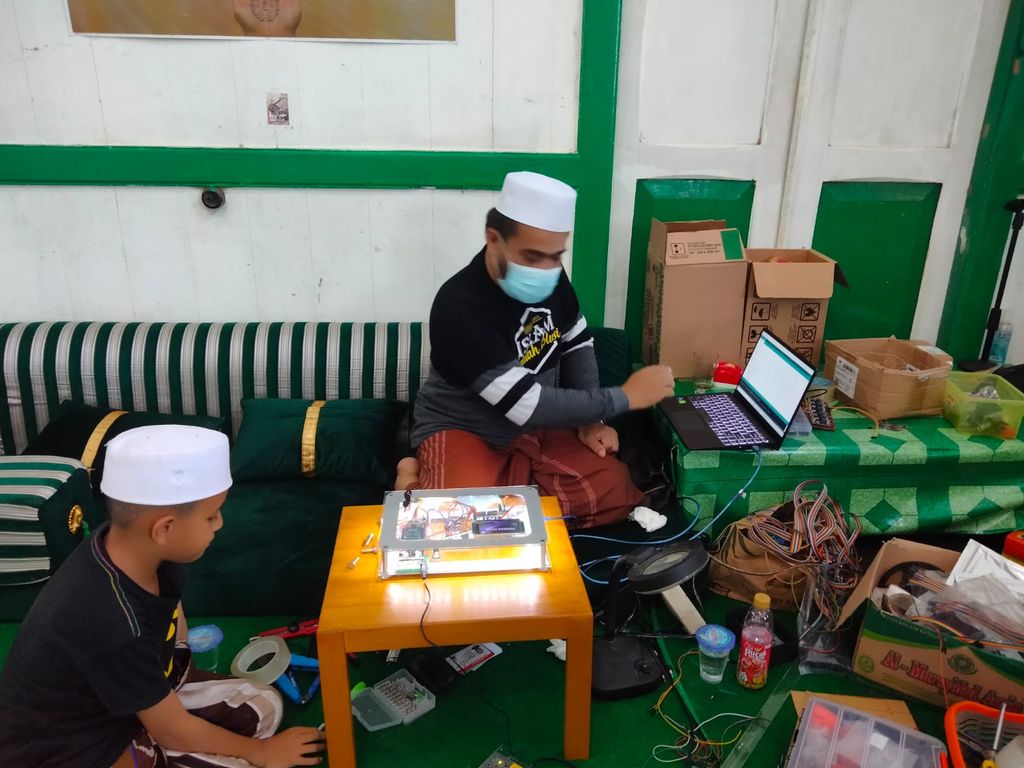 Habib Fathurrahman Bahasyim memperlihatkan alat Smart Checker pemindai e-KTP yang bisa digunakan untuk mengecek peserta vaksinasi. (Muhammad Risanta/detikcom)