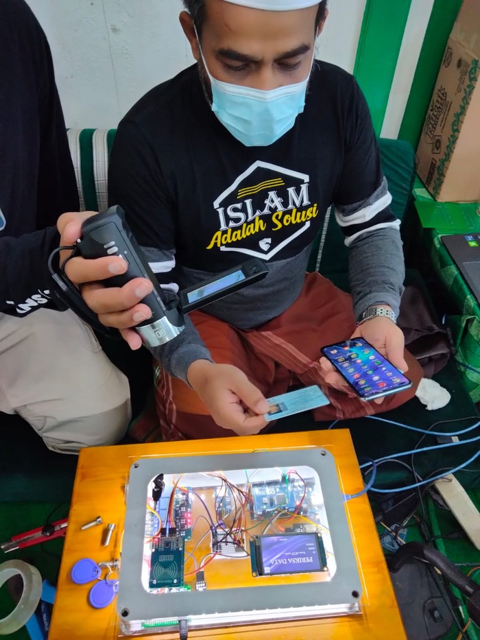 Habib Fathurrahman Bahasyim memperlihatkan alat Smart Checker pemindai e-KTP yang bisa digunakan untuk mengecek peserta vaksinasi. (Muhammad Risanta/detikcom)
