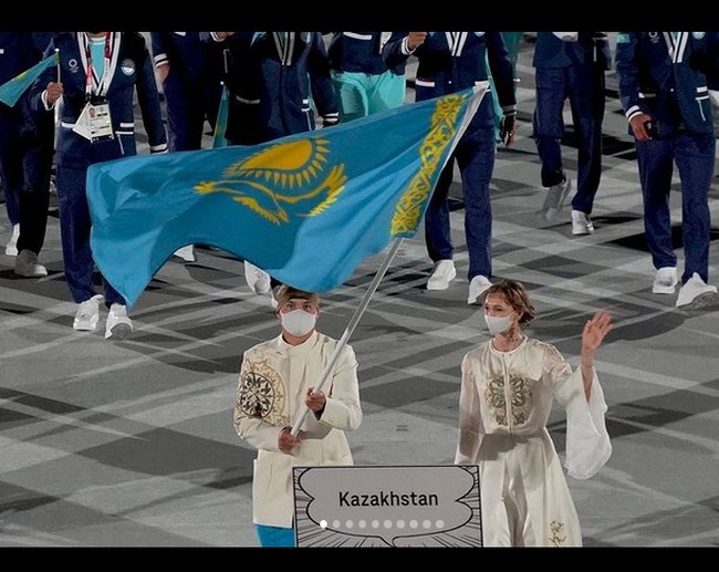 Olga tampil mengenakan dress putih dengan sulaman. Rambutnya dicepol, dan mengenakan anting menjuntai. Foto: dok. Instagram/@olgarypakova_official