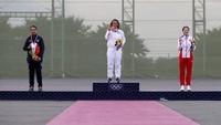 Namun ada batasnya, masker boleh dilepas hanya 30 detik saja lalu berfoto dengan medalinya. Kemudian, masker harus kembali dipakai. Kevin C. Cox/Getty Images.