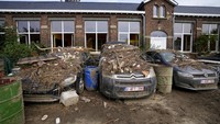 Penampakan sejumlah kendaraan roda empat yang tampak dipenuhi sampah usai banjir besar di Belgia surut.