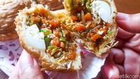 Pastel berbentuk bulat mirip ufo ini begitu unik. Isiannya padat melimpah, berupa tumisan wortel, buncis, sohun, ayam suwir, dan telur puyuh. Rasanya gurih dan renyah yang nagih banget! Foto: detikFood/Yenny Mustika Sari
