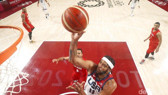 United States' Javale Mc Gee (11), center, is fouled by Iran's Pujan Jalalpoor (5), left, during men's basketball preliminary round game at the 2020 Summer Olympics, Wednesday, July 28, 2021, in Saitama, Japan. (AP Photo/Eric Gay)