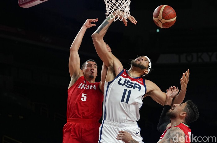 Tokyo Olympics Basketball United States' Javale Mc Gee (11), center, is fouled by Iran's Pujan Jalalpoor (5), left, during men's basketball preliminary round game at the 2020 Summer Olympics, Wednesday, July 28, 2021, in Saitama, Japan. (AP Photo/Eric Gay)