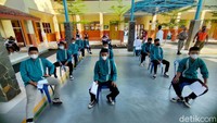 Anak-anak menjaga karak saat menunggu divaksin.