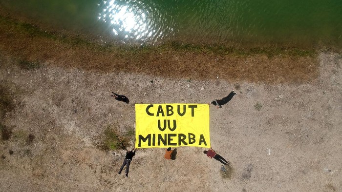 Sejumlah pengabdi bantuan hukum (PBH) LBH Padang, melakukan aksi guna menuntut pencabutan UU Minerba di kawasan lubang tambang batubara di Talawi, Sawahlunto, Sumatera Barat, Kamis (29/7/2021). Aksi tersebut digelar untuk mendukung Hak Uji Materil Undang-undang Mineral dan Batubara (UU-Minerba) ke Mahkamah Konstitusi yang dilakukan YLBHI, Jatam, LBH Bandung, LBH Padang, warga Banyuwangi dan warga Bangka Belitung, agar undang-undang tersebut dicabut karena dinilai sangat berdampak buruk terhadap lingkungan.  ANTARA FOTO/Iggoy el Fitra/aww.