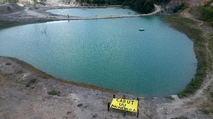 Aksi Cabut UU Minerba di Tambang Batubara Sejumlah pengabdi bantuan hukum (PBH) LBH Padang, melakukan aksi guna menuntut pencabutan UU Minerba di kawasan lubang tambang batubara di Talawi, Sawahlunto, Sumatera Barat, Kamis (29/7/2021). Aksi tersebut digelar untuk mendukung Hak Uji Materil Undang-undang Mineral dan Batubara (UU-Minerba) ke Mahkamah Konstitusi yang dilakukan YLBHI, Jatam, LBH Bandung, LBH Padang, warga Banyuwangi dan warga Bangka Belitung, agar undang-undang tersebut dicabut karena dinilai sangat berdampak buruk terhadap lingkungan. ANTARA FOTO/Iggoy el Fitra/aww.