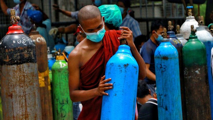 A man holds an oxygen tank while waiting outside the Naing oxygen factory at the South Dagon industrial zone in Yangon, Myanmar, Wednesday, July 28, 2021. Myanmar is currently reeling from soaring numbers of COVID-19 cases and deaths that are badly straining the country’s medical infrastructure.  (AP Photo)