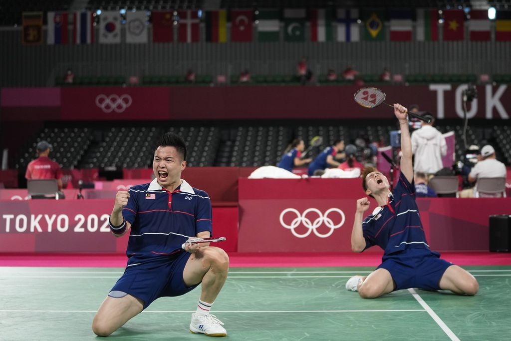 Malaysia's Aaron Chia and Soh Wooi Yik celebrate after defeating Indonesia's Marcus Fernaldi Gideon and Kevin Sanjaya Sukamuljo during their men's doubles quarterfinal match at the 2020 Summer Olympics, Thursday, July 29, 2021, in Tokyo, Japan. (AP Photo/Dita Alangkara)