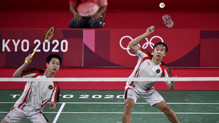 Pebulutangkis ganda putra Indonesia Marcus Fernaldi Gideon/Kevin Sanjaya Sukamuljo meninggalkan lapangan seusai kalah dari ganda putra Malaysia Aaron Chia/Wooi Yik Soh dalam perempat final Olimpiade Tokyo 2020 di Musashino Forest Sport Plaza, Tokyo, Jepang, Kamis (29/7/2021). Marcus Fernaldi Gideon/Kevin Sanjaya Sukamuljo gagal melangkah ke semifinal setelah kalah 14-21, 17-21. ANTARA FOTO/Sigid Kurniawan/aww.