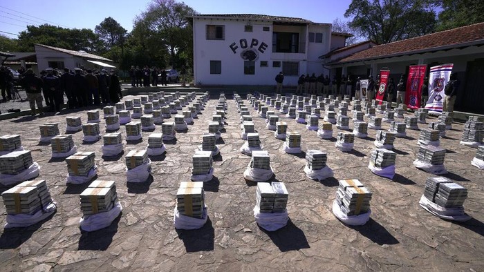 Rekor! Polisi Paraguay Berhasil Sita 3 Ton Kokain Police stand guard over seized cocaine that is displayed to the press at the Special Forces Police headquarters in Asuncion, Paraguay, Wednesday, July 28, 2021. According Interior Minister Arnaldo Giuzzio, a record amount of 3,415 kilograms (7,528 pounds) of cocaine was found in sacks of organic sugar in a warehouse in the city of Fernando de la Mora on July 27. (AP Photo/Jorge Saenz)