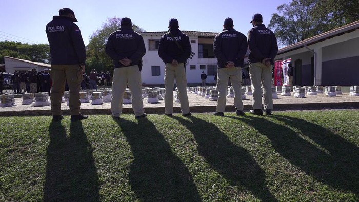 Rekor! Polisi Paraguay Berhasil Sita 3 Ton Kokain Police stand guard over seized cocaine that is displayed to the press at the Special Forces Police headquarters in Asuncion, Paraguay, Wednesday, July 28, 2021. According Interior Minister Arnaldo Giuzzio, a record amount of 3,415 kilograms (7,528 pounds) of cocaine was found in sacks of organic sugar in a warehouse in the city of Fernando de la Mora on July 27. (AP Photo/Jorge Saenz)