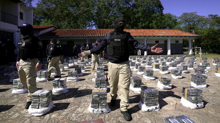 Police stand guard over seized cocaine that is displayed to the press at the Special Forces Police headquarters in Asuncion, Paraguay, Wednesday, July 28, 2021. According Interior Minister Arnaldo Giuzzio, a record amount of 3,415 kilograms (7,528 pounds) of cocaine was found in sacks of organic sugar in a warehouse in the city of Fernando de la Mora on July 27. (AP Photo/Jorge Saenz)